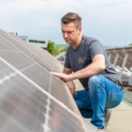 Photovoltaik für Gewerbedächer: Ein Monteur auf einem Flachdach überprüft die Installation von Photovoltaikmodulen.