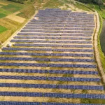 Luftaufnahme einer großen Photovoltaik Freiflächen Anlage mit zahlreichen Reihen von Solarmodulen.