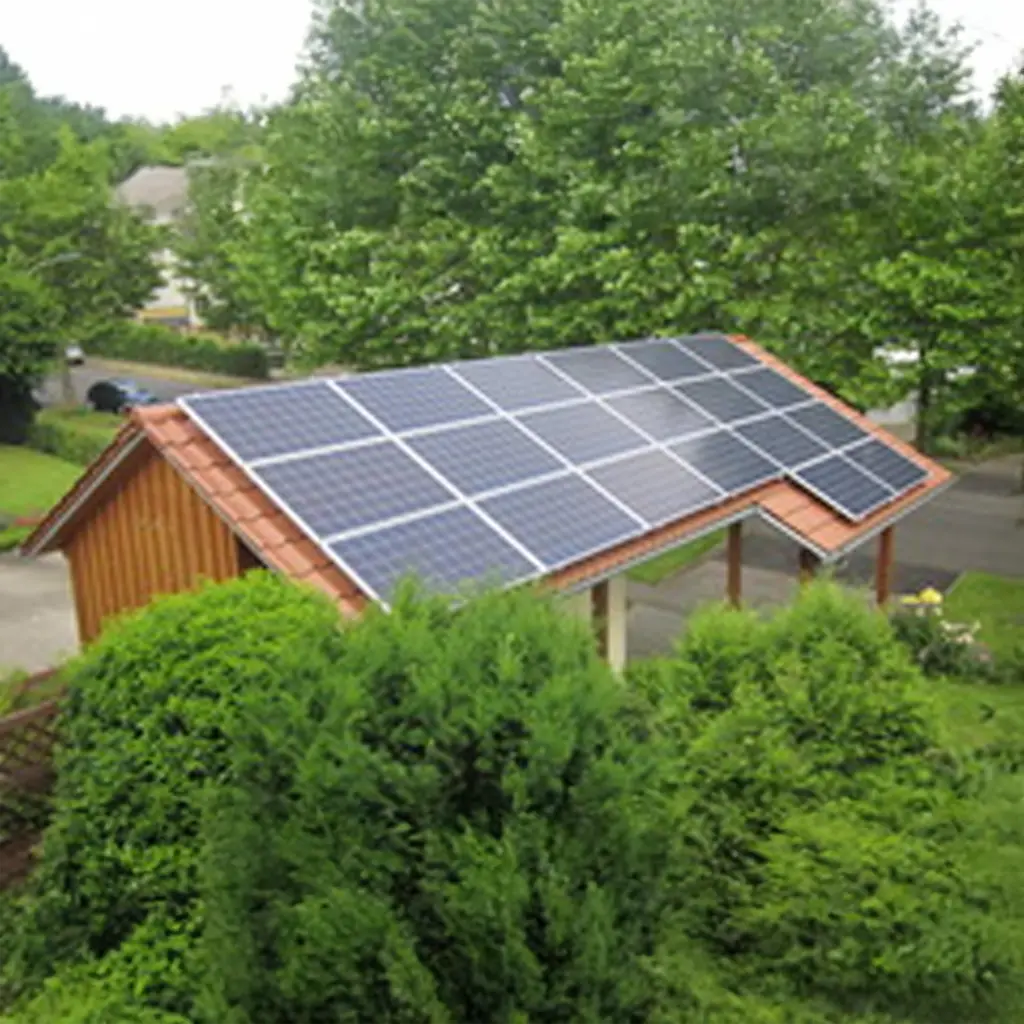 Photovoltaik auf Carport: Solarmodule auf dem roten Dach eines Carports, umgeben von Büschen.