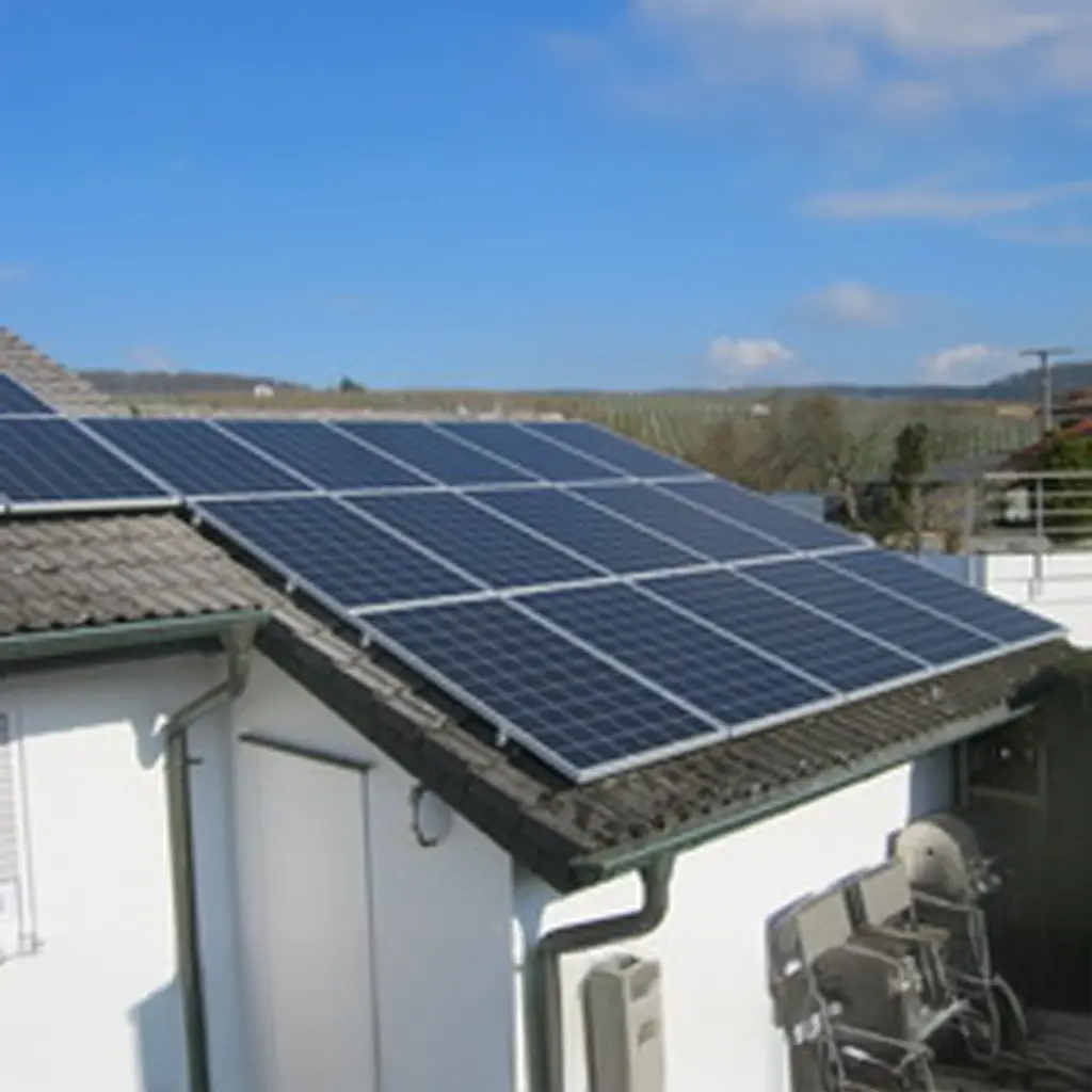 Photovoltaik Weinsberg: Dunkle Solarmodule auf Hausdach vor Weinbergen bei Sonnenschein.