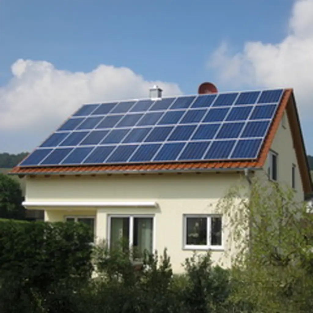 Photovoltaik Weinsberg: Großflächige Solaranlage auf Hausdach mit roten Ziegeln und blauem Himmel.