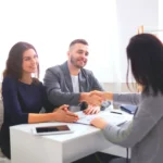 Paar besiegelt nach Beratung den Kunden werben Kunden Abschluß mit einem Handschlag.